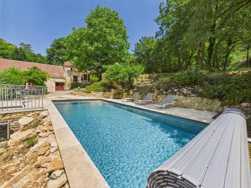 une piscine avec un banc devant une maison dans l'établissement Salignac-Eyvigues, maison pour 7 avec piscine, à Salignac Eyvigues
