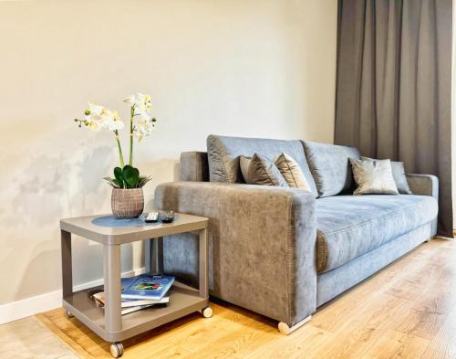 a living room with a blue couch and a table at Uniwersytecki by Rentoom in Toruń