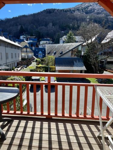 a balcony with a table and a view of a city at Séjour SPA inclus au centre de St Lary in Saint-Lary-Soulan