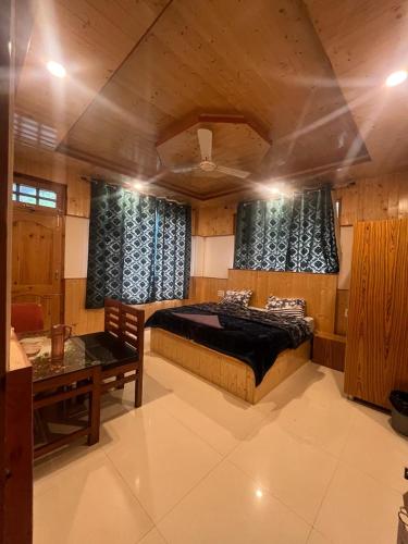 Un dormitorio con una cama y una mesa dentro. en Manali luxury Hotel - By Naina rockland, en Bashist