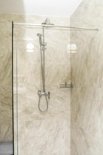a shower with a glass door in a bathroom at Belveder in Rohatyn