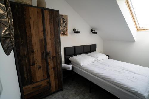 a small bedroom with a bed and a wooden door at Apartamenty pod Gromadzyniem Górski Relaks in Ustrzyki Dolne