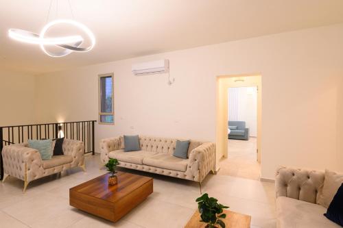 a living room with couches and a table at וילה לוזאן - Lausanne Villa in Dāliyat el Karmil