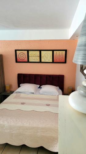 une chambre avec un lit avec quatre tableaux au mur dans l'établissement Suite and garden BLUE EDEN, plages de Saint-Raphaël Côte d Azur, à Saint-Raphaël