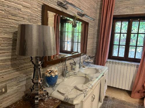 ein Badezimmer mit einem Waschbecken, einer Lampe und einem Spiegel in der Unterkunft Il Rifugio di Anna Maria in Chieti