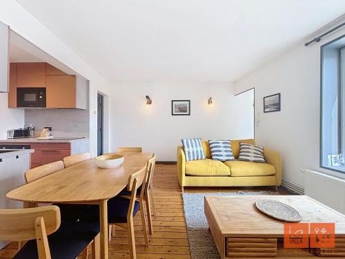 un salon avec une table et un canapé jaune dans l'établissement Les Hirondelles, à Wimereux