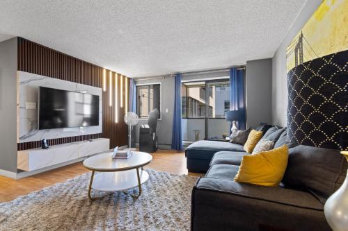 a living room with a couch and a tv at Modern 2 bedroom next to Stampede, 17th w Parking in Calgary