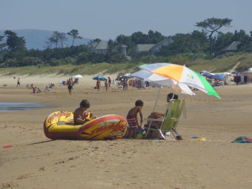 a group of children sitting on a beach with an inflatable at Green Park Departamentos Exclusivos in Punta del Este
