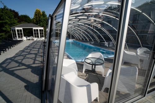 a balcony with white chairs and a swimming pool at Apartamenty pod Gromadzyniem Górski Relaks in Ustrzyki Dolne