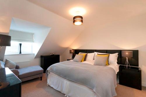 a bedroom with a large bed and a chair at DBS Serviced Apartments - The Terrace in Castle Donington