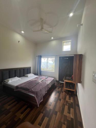 a bedroom with a large bed and a window at Happy Homestay And Rooftop cafe in Chamba