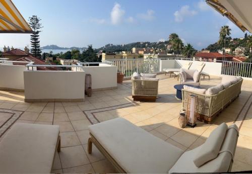a patio with couches and chairs on a roof at Résidence Carlton - Rénovée avec Piscine in Beaulieu-sur-Mer