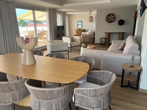 a living room with a couch and a table and chairs at Résidence Carlton - Rénovée avec Piscine in Beaulieu-sur-Mer