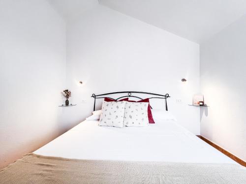 a bedroom with a white bed with red pillows at Casa degli ulivi 1 in Olbia