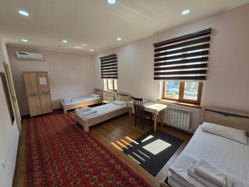 a room with a bedroom with two beds and a table at Donish Hotel in Bukhara