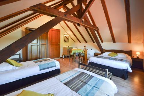 a attic room with three beds and a table at Gîte Oncle Yerry Ostheim in Ostheim