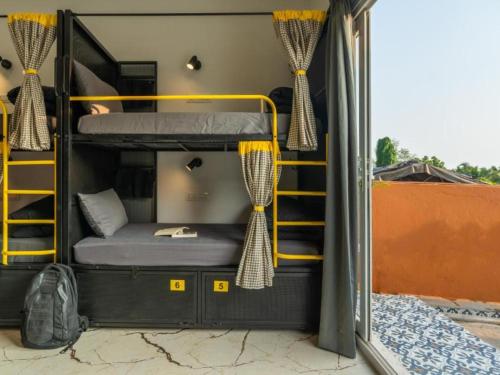a room with bunk beds inside of a bus at The Hosteller Goa, Mandrem in Mandrem