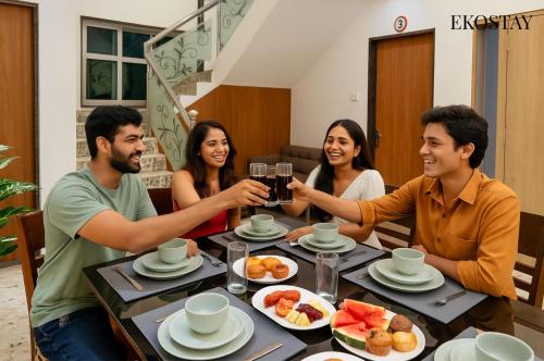 a group of people sitting around a table drinking wine at EKOSTAY - Golden Oasis in Alibaug