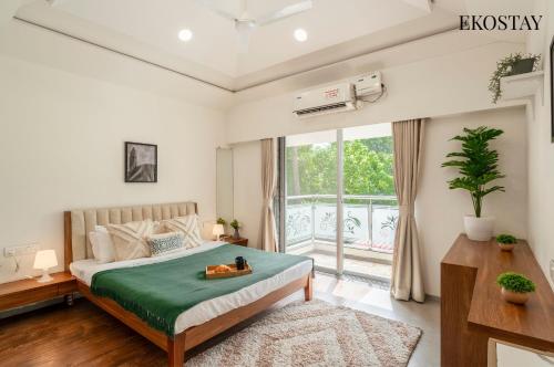 a bedroom with a bed and a large window at EKOSTAY - Golden Oasis in Alibaug