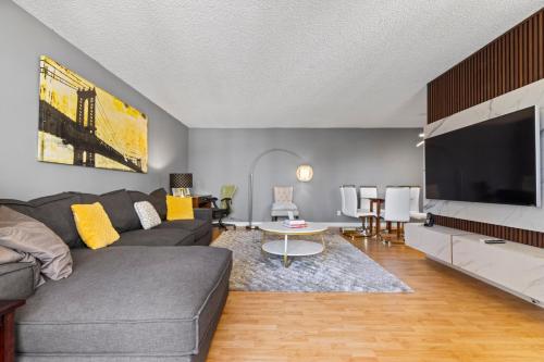 a living room with a couch and a tv at Modern 2 bedroom next to Stampede, 17th w Parking in Calgary