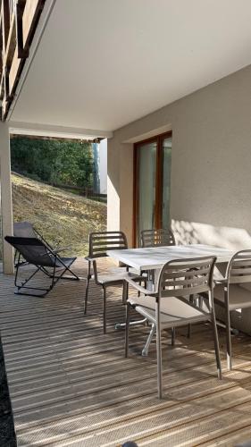 un patio avec une table et des chaises sur une terrasse dans l'établissement Coeur des Ours B N01 - 3P6, à Les Deux Alpes