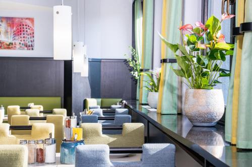 a lobby with chairs and a vase of flowers at HOTEL Am Spichernplatz in Düsseldorf