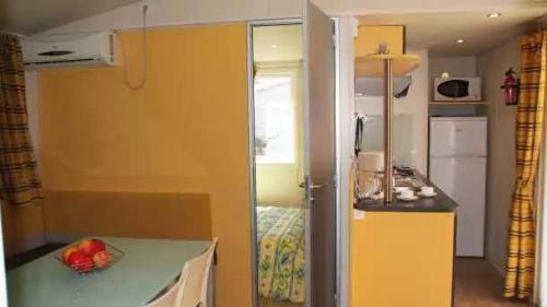 a small room with a kitchen and a room with a bed at Appartement 4 étoiles - Parc aquatique - ccaa0ai in Bormes-les-Mimosas
