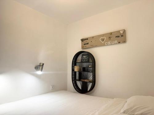 Cette chambre comprend un lit et un mur avec une étagère. dans l'établissement Appartement face à la mer, à Saint-Raphaël