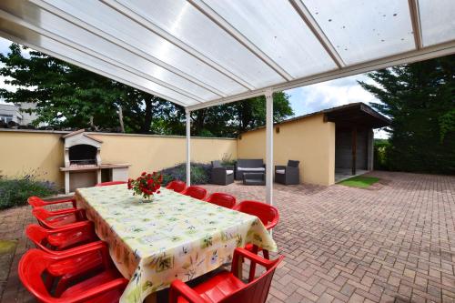 a table and chairs under a white pergola at Gîte Oncle Yerry Ostheim in Ostheim