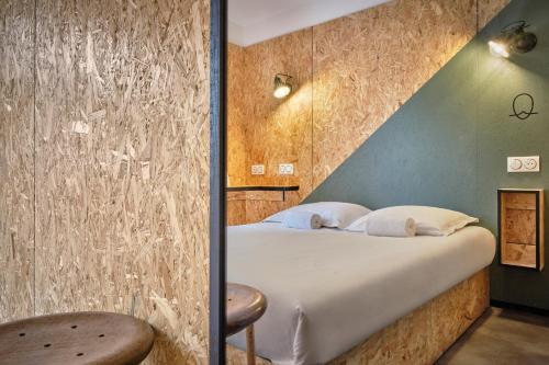 a bedroom with a bed with a wall at The Originals Access, Hôtel Moustache, Seclin in Seclin