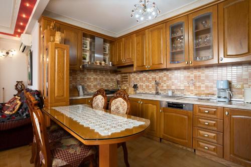 a kitchen with wooden cabinets and a table with chairs at Apartments Vlora Holidays in Vlorë