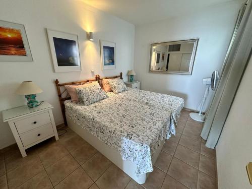 a bedroom with a bed and a table with a lamp at Roca Negra in Puerto del Carmen