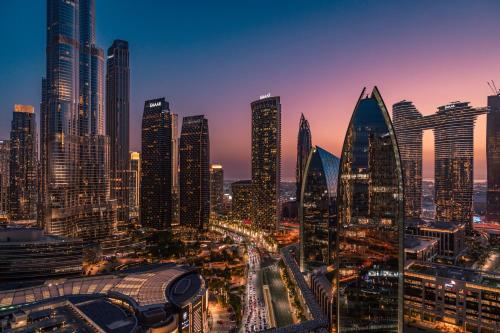 a city skyline at night with tall buildings at Fashion Avenue Dubai Mall in Dubai