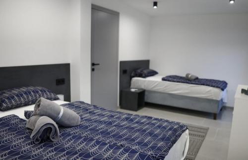 a bedroom with two beds with blue and white sheets at Villa L&M in Bihać