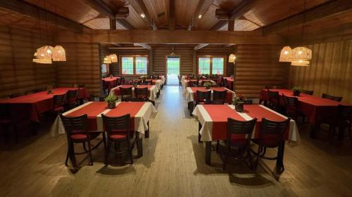 a restaurant with red tables and chairs in a room at Коттедж на берегу живописного озера in Kerimäki