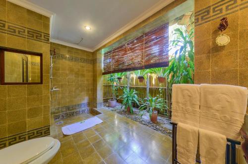 a bathroom with a shower and a toilet in it at Seahorse Resort & Spa in Mui Ne