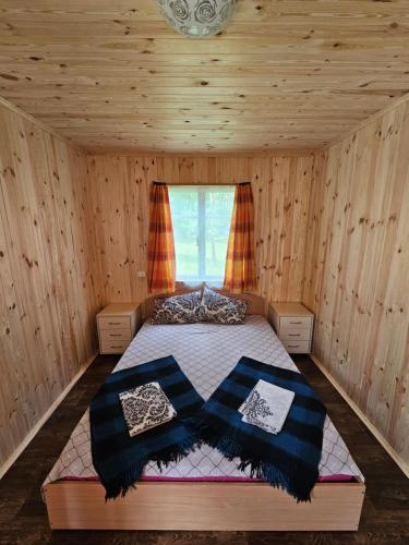 a bedroom with a bed in a wooden cabin at База відпочинку Енергія in Rudnya Peskovskaya