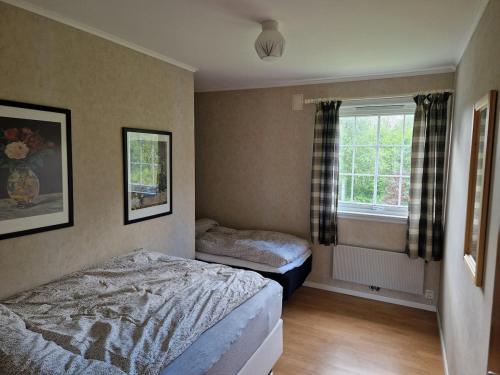 a bedroom with two beds and a window at Hus med stor hage ved Vatsfjorden in Åmsosen