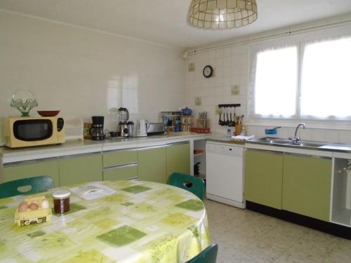 - une cuisine avec une table et un four micro-ondes dans l'établissement chez MAJOS un HAVRE DE PAIX, à La Celle-sous-Gouzon