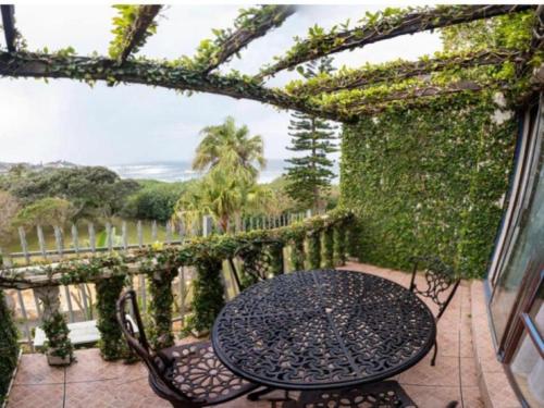 a patio with a table and chairs on a balcony at Gracelands Beach Lodge in Ramsgate