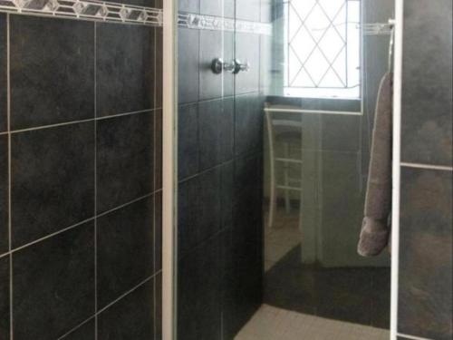 a shower with a glass door in a bathroom at Gracelands Beach Lodge in Ramsgate