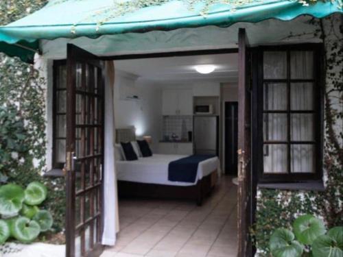 a bedroom with a bed in a room with atained at Gracelands Beach Lodge in Ramsgate