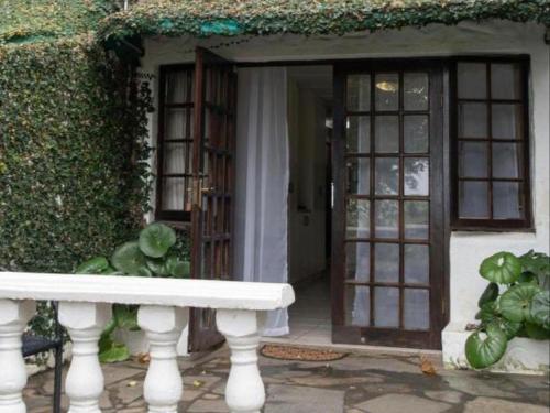 a white bench in front of a house with a door at Gracelands Beach Lodge in Ramsgate