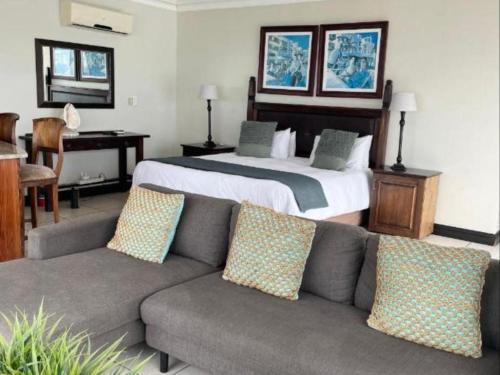 a bedroom with a bed and a couch and a bed at Gracelands Beach Lodge in Ramsgate