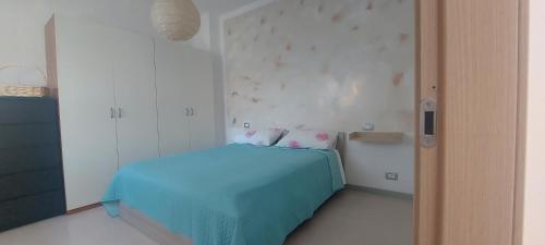a bedroom with a blue bed in a room at Casa San Giovanni, apartment in the center in Borgomanero