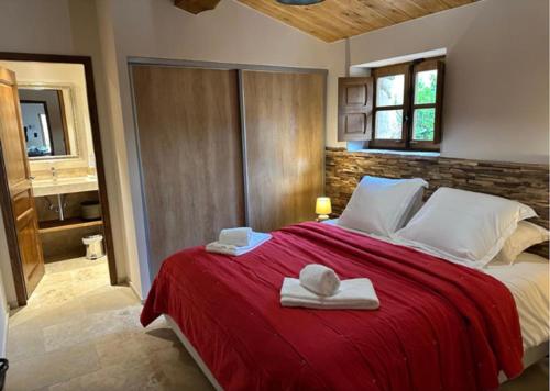 a bedroom with a red bed with towels on it at La BERGERIE de la CRIQUE BLEUE in Conca