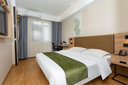 a hotel room with a large bed and a desk at GreenTree Inn in Shanghai