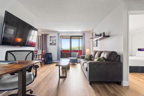 a living room with a couch and a table at Suite near Downtown, BMO, Stampede, Free Parking in Calgary
