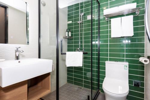 a green tiled bathroom with a toilet and a sink at GreenTree Inn in Shanghai