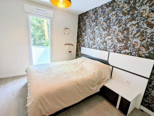 a bedroom with a bed and a floral wall at T3 neuf Baignots proche Thermes, centre, parking in Dax